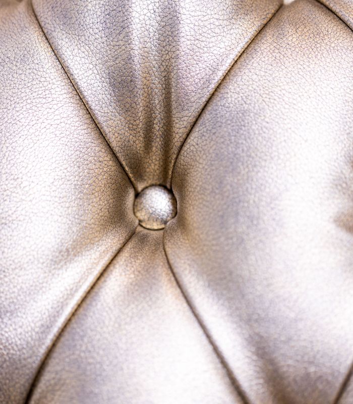 Close-up of a tufted metallic chair upholstery.